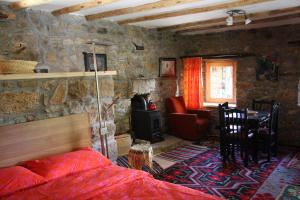 a bedroom with a bed and a stone wall at Guest House Ktona in Dardhë