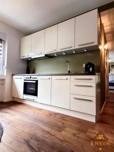 a kitchen with white cabinets and a stove top oven at Top Modernes Rhein Apartment Vallendar mit Balkon in Vallendar