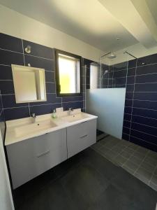ein Badezimmer mit 2 Waschbecken und einem Spiegel in der Unterkunft maison moderne à guidel plage in Guidel