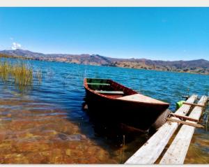 a boat sitting on the water next to a dock at Madervill Hospedaje in Aquitania