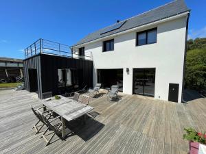 eine Terrasse mit einem Tisch und Stühlen auf einer Terrasse in der Unterkunft maison moderne à guidel plage in Guidel