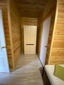 a room with a white door and wooden walls at Апартаменты в Леонидово in Sanzhiyka
