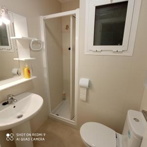 a white bathroom with a toilet and a sink at Martina Maria Beach in Benidorm +24 photos