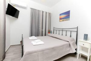 a bedroom with a bed and a flat screen tv at Giannis sea-view apartment in Katávolos