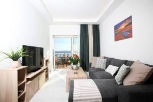 a living room with a couch and a tv at Giannis sea-view apartment in Katávolos
