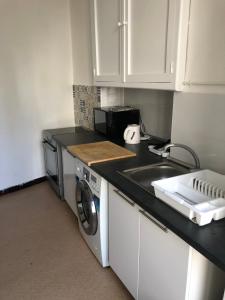 a kitchen with a sink and a washing machine at La Promenade House in Nice
