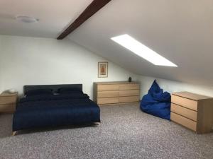 - une chambre avec un lit et une couverture bleue dans l'établissement Apartmány v pivovaru, à Kašperské Hory