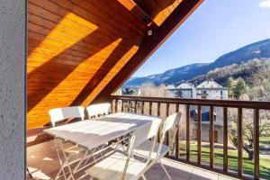 a deck with a table and chairs on a balcony at Appartement style chalet à Saint Lary Soulan. in Saint-Lary-Soulan