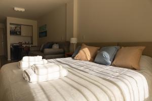 1 dormitorio con 1 cama grande y toallas. en San Martin Studio en San Carlos de Bariloche