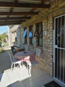 a table and chairs sitting on a patio at Beautiful Sea View Room in Jeffreys Bay