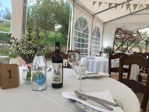 una mesa con una botella de vino y una copa en Hostal- Restaurante Estación Vía Verde, en Olvera