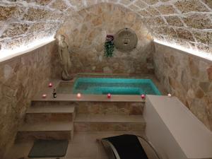 una vasca da bagno in un edificio in pietra con piscina di L'Incanto di Venere a Casarano