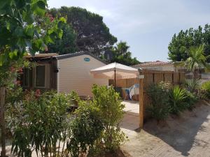a house with an umbrella and a patio at Mobilhome Pampelonne Jacobs in Saint-Tropez