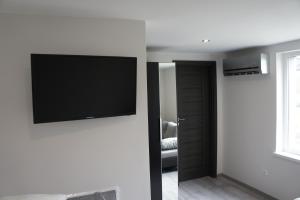 a living room with a flat screen tv on a wall at Pueblo Pokoje in Stegna