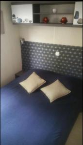 a bedroom with a blue bed with two pillows at Mobilhomme bungalow 6 personnes villeneuve loubet marina baie des anges in Villeneuve-Loubet