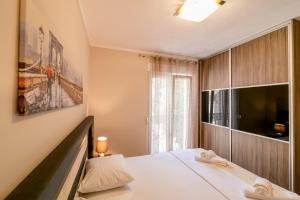 een slaapkamer met een bed en een groot raam bij Apartmani Matej in Kotor