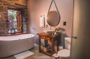 a bathroom with a tub and a sink and a toilet at Casa Vêneto -Vale dos Vinhedos in Bento Gonçalves
