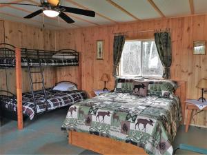 a bedroom with two bunk beds and a ceiling fan at WildExodus Outdoors in Timmins