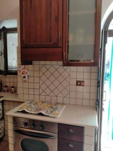 a kitchen with wooden cabinets and a stove top oven at La Bomboniera Cascia in Cascia