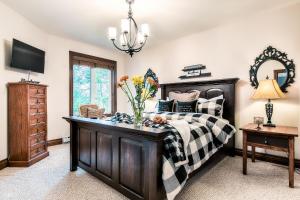 a bedroom with a bed and a table with a vase of flowers at Townhouse On The Golf La Bte -10min To Tremblant in Mont-Tremblant