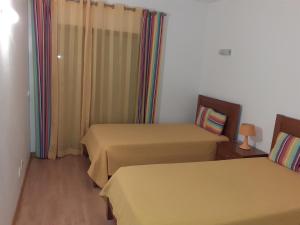 a room with two beds and a window at Clube Meia Praia in Lagos