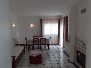 a living room with a table and chairs and a window at Clube Meia Praia in Lagos