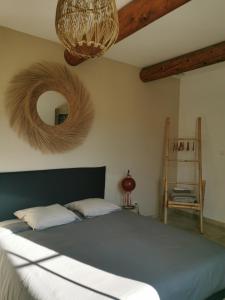 een slaapkamer met een groot bed en een spiegel bij LA PARENTHESE in Manduel
