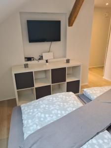 ein Schlafzimmer mit einem Bett und einem Fernseher auf einem Regal in der Unterkunft Ferienwohnung Ohanna Goslar in Goslar