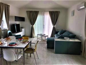 a living room with a blue couch and a table at - La Casa delle Meraviglie- Anima Sarda in Porto Pino