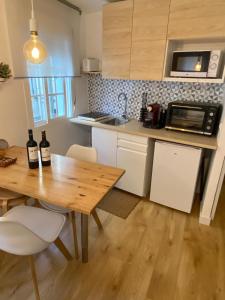 una cocina con mesa de madera y 2 botellas de vino en Duplex Casco Histórico en Pontevedra