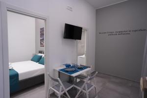 - une chambre avec un lit et un bureau avec deux chaises dans l'établissement Natola's Home, à Margherita di Savoia