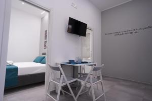 Cette chambre dispose d'une table, de deux chaises et d'une télévision. dans l'établissement Natola's Home, à Margherita di Savoia
