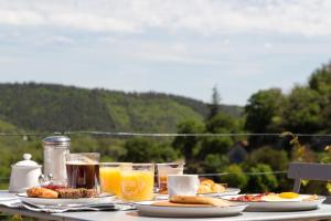a table with plates of food and glasses of orange juice at Maison Lapopie chambres et gîte in Saint-Cirq-Lapopie