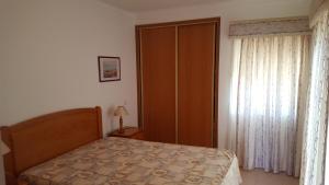 a bedroom with a bed and a large window at Clube Meia Praia in Lagos