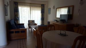 a living room with a table and a television at Clube Meia Praia in Lagos