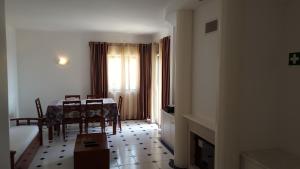a dining room with a table and chairs and a window at Clube Meia Praia in Lagos