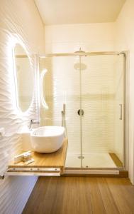 uma casa de banho com uma cabina de duche em vidro e um lavatório. em Volver B&B em Gaeta