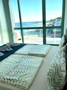 two beds in a bedroom with a view of the ocean at BEACH APARTMENT no 17 in St. St. Constantine and Helena