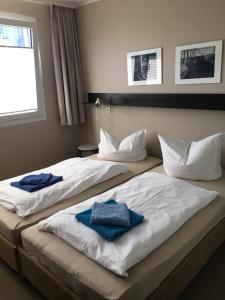 two beds in a hotel room with towels on them at Haus Störtebeker in Ahlbeck