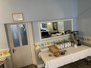 a kitchen with a table and a mirror and a counter at The Boyce Hotel in Blackpool