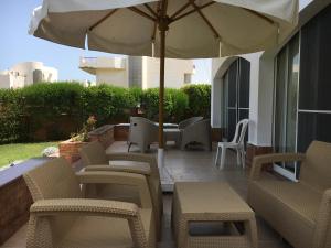 a patio with tables and chairs and an umbrella at Luxury Villa Panorama Beach in El Alamein