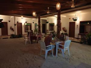 un grupo de personas sentadas en mesas en un restaurante en Summer Sky Thoddoo, en Thoddoo 50 fotos más
