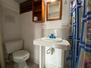 a bathroom with a white sink and a toilet at Hotel San Felipe de Jesus Yucatan in San Felipe