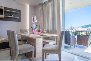 una sala da pranzo con tavolo e sedie e un balcone di zakynthos town modern roof apartment a Città di Zante