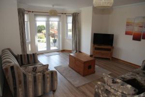 a living room with a couch and a tv at BELL ROCK VIEW ARBROATH in Angus
