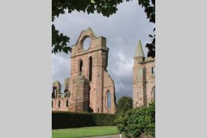 an old stone building with a clock tower on it at BELL ROCK VIEW ARBROATH in Angus