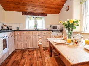 a kitchen with wooden cabinets and a wooden table at Sandywood in Skipton