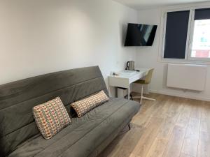 a living room with a couch and a desk at Nanterre Room in Nanterre