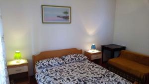 a bedroom with a bed and a couch and two lamps at Apartment in Silo/Insel Krk 14603 in Šilo