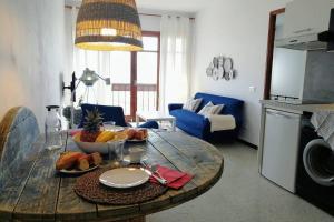 una sala de estar con una mesa de madera con comida. en Casa Melchor, amanecer y trabajar mirando al mar, en Santa Cruz de la Palma